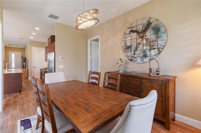 dining area with sink and light wood-type flooring