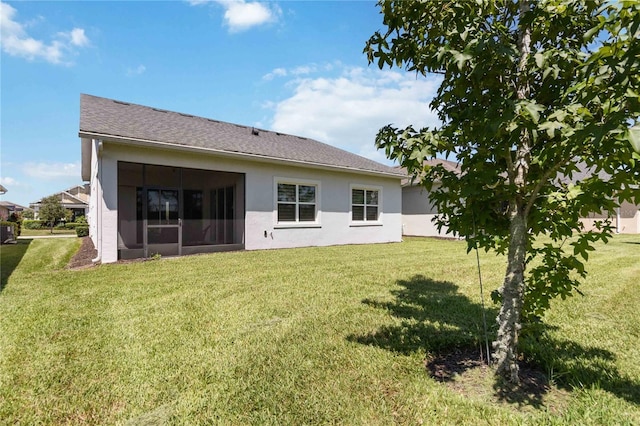 back of house with a yard and a sunroom