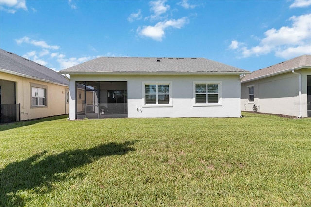 rear view of house with a sunroom and a yard