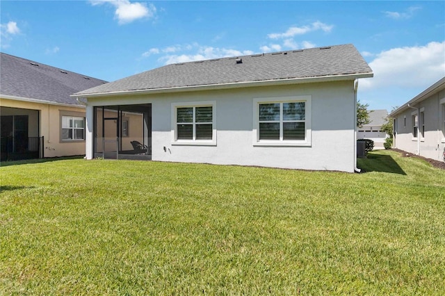 back of property with a sunroom and a lawn