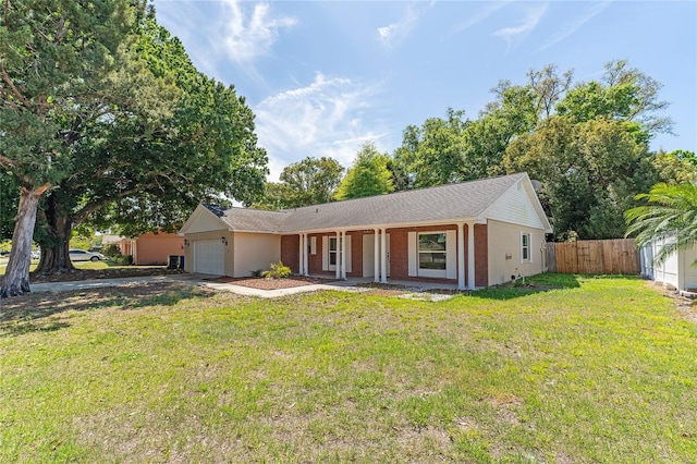 ranch-style home featuring a garage and a front lawn