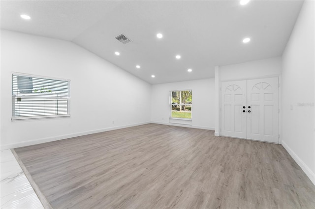 unfurnished living room with lofted ceiling, recessed lighting, visible vents, baseboards, and light wood finished floors