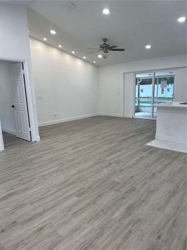 unfurnished living room with ceiling fan, recessed lighting, wood finished floors, visible vents, and baseboards