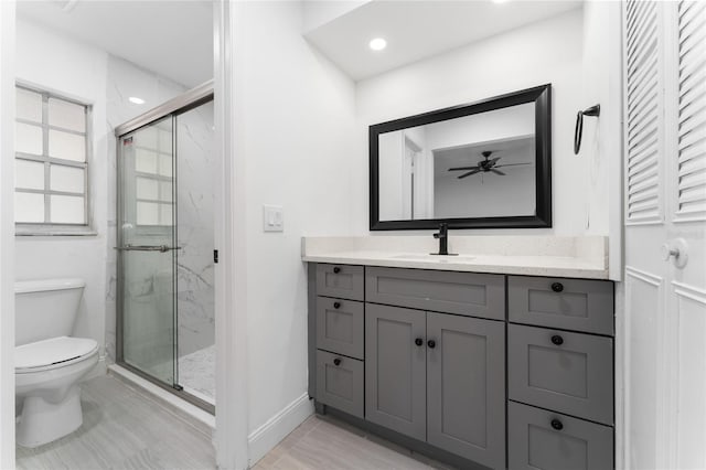 full bath with a marble finish shower, recessed lighting, toilet, vanity, and baseboards