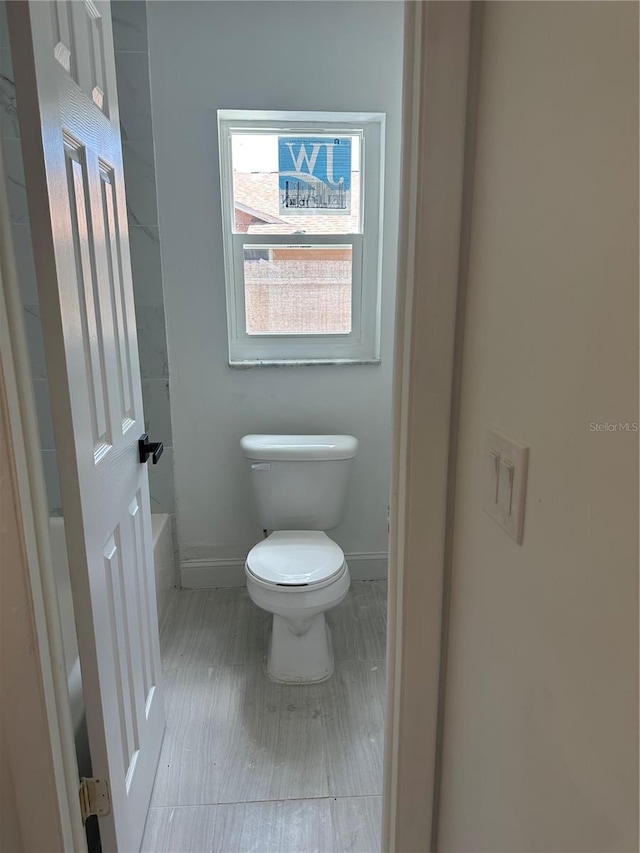 bathroom featuring toilet and baseboards