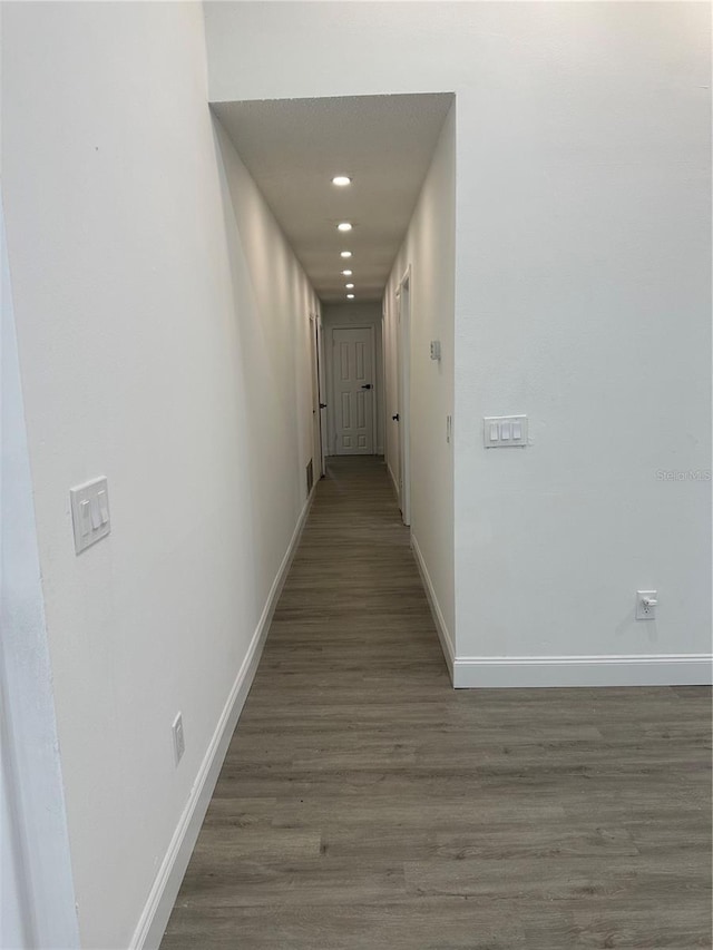 hallway with recessed lighting, baseboards, and wood finished floors