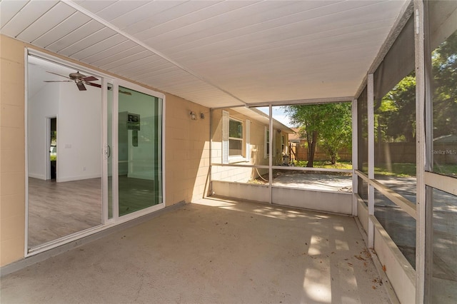 unfurnished sunroom featuring a ceiling fan