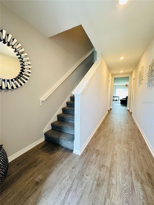 staircase with hardwood / wood-style floors