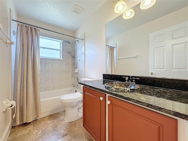 full bathroom featuring vanity, toilet, a textured ceiling, and shower / bath combo