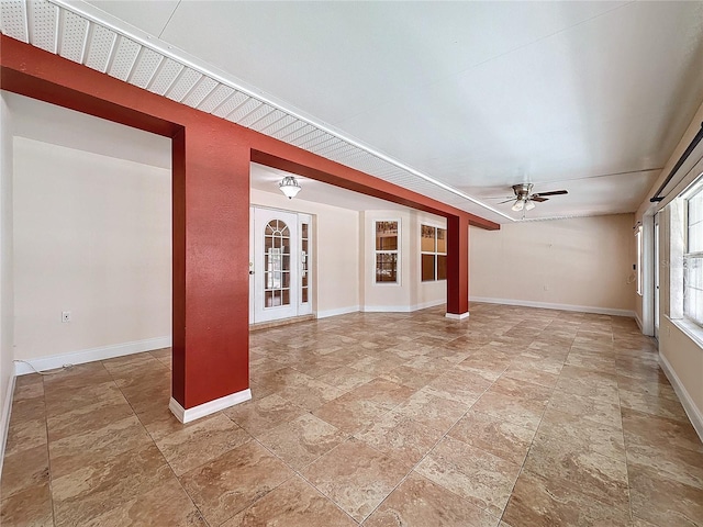 unfurnished living room featuring french doors and ceiling fan