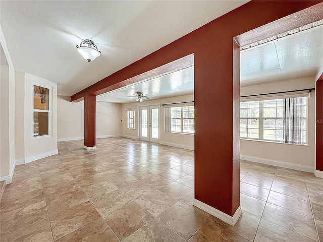 unfurnished living room featuring ceiling fan and a textured ceiling