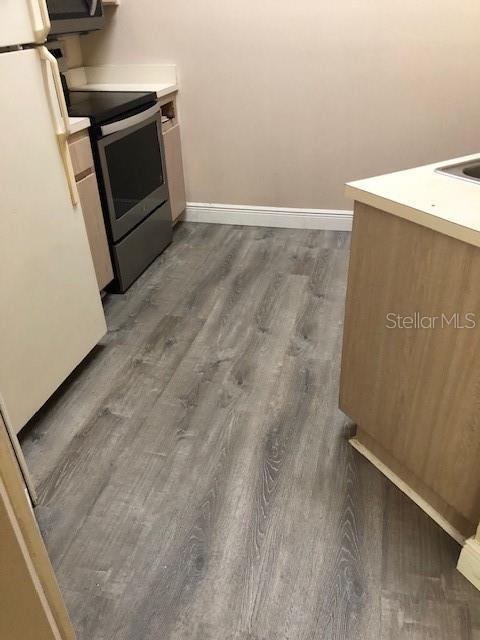 kitchen with hardwood / wood-style flooring and appliances with stainless steel finishes