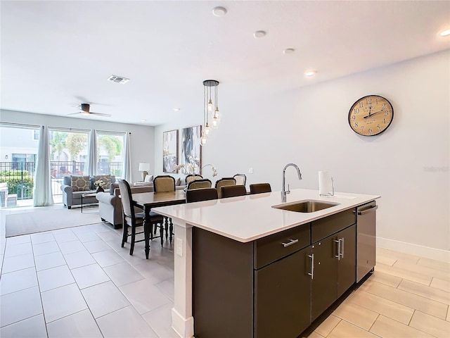 kitchen featuring sink, decorative light fixtures, an island with sink, dishwasher, and ceiling fan