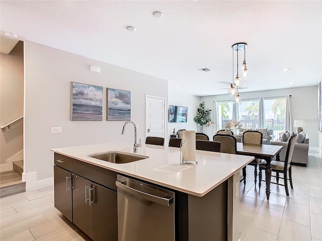 kitchen with sink, decorative light fixtures, dishwasher, and an island with sink