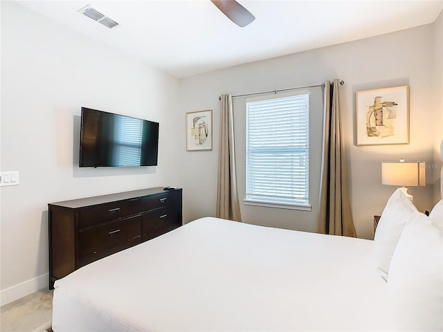 bedroom featuring multiple windows, ceiling fan, and light colored carpet