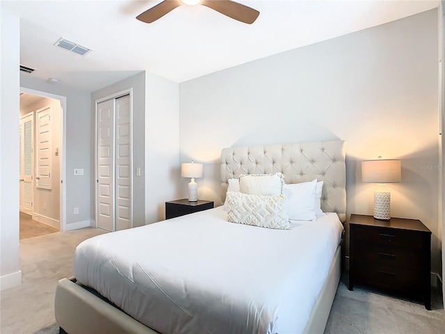 bedroom featuring light colored carpet, a closet, and ceiling fan