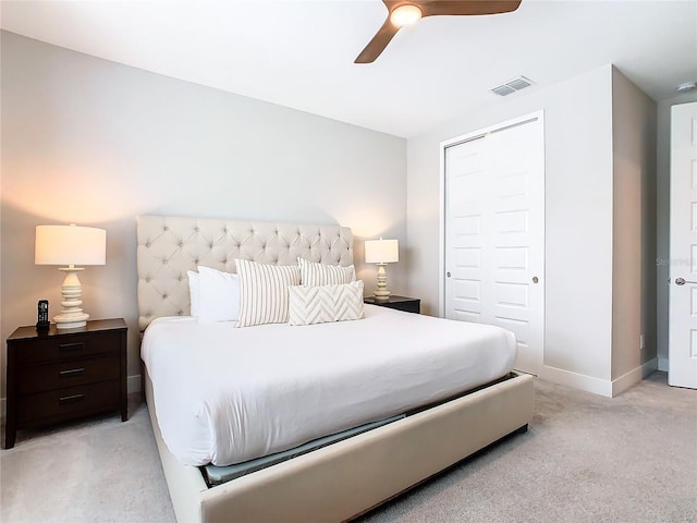 bedroom featuring a closet, light colored carpet, and ceiling fan