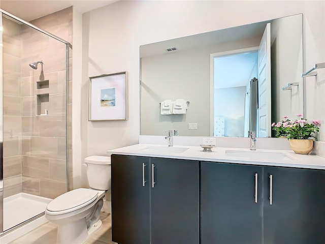 bathroom with a shower with shower door, toilet, and double vanity