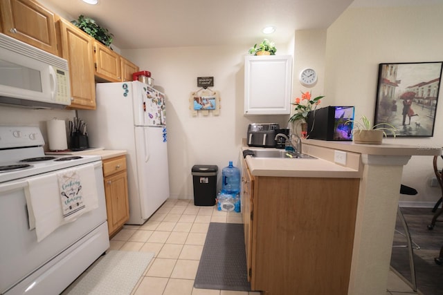 kitchen featuring light brown cabinetry, sink, light tile patterned floors, and white appliances