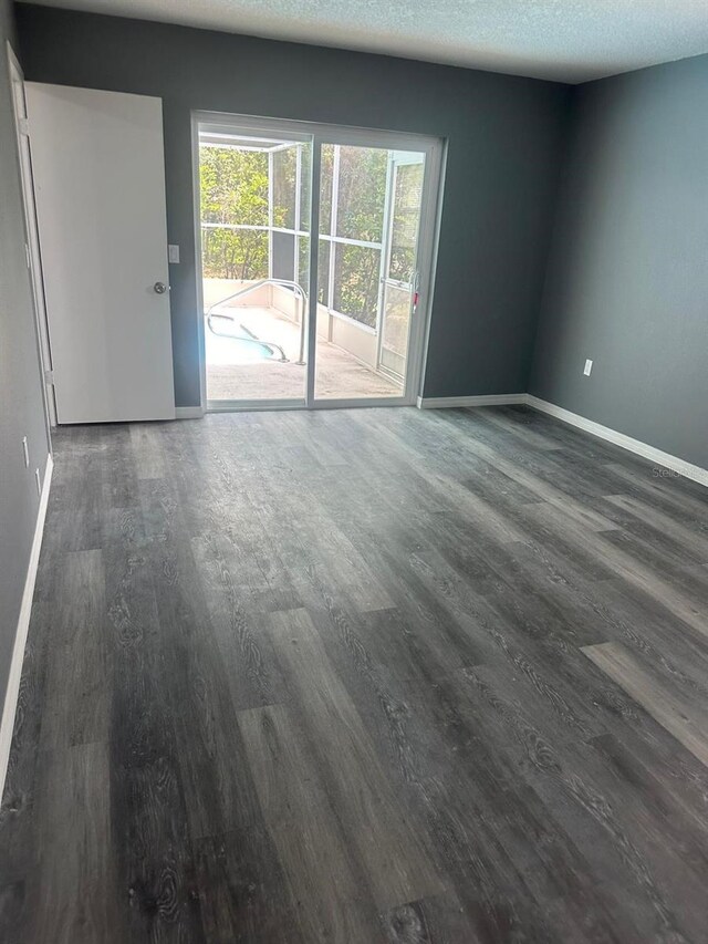 empty room with a textured ceiling and hardwood / wood-style floors