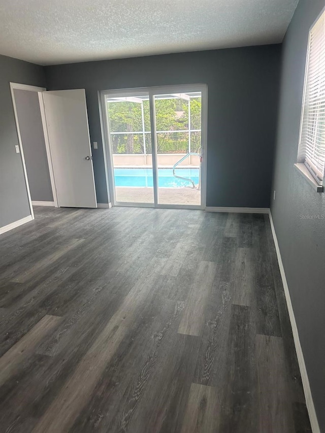 unfurnished room with hardwood / wood-style flooring, a textured ceiling, and plenty of natural light