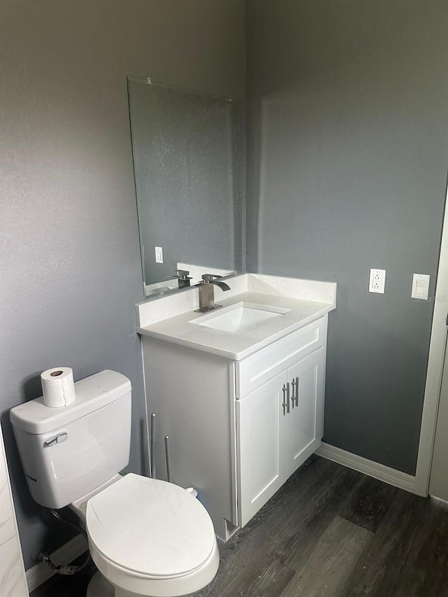 bathroom featuring vanity, wood-type flooring, and toilet