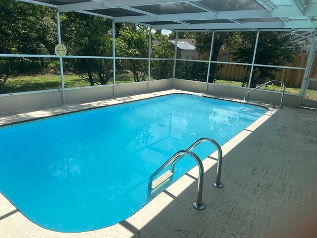 view of swimming pool featuring a patio area and a lanai