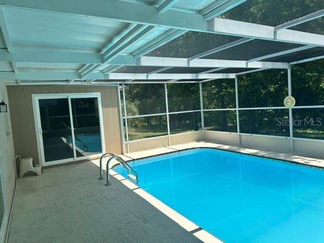 view of swimming pool featuring a patio and a lanai