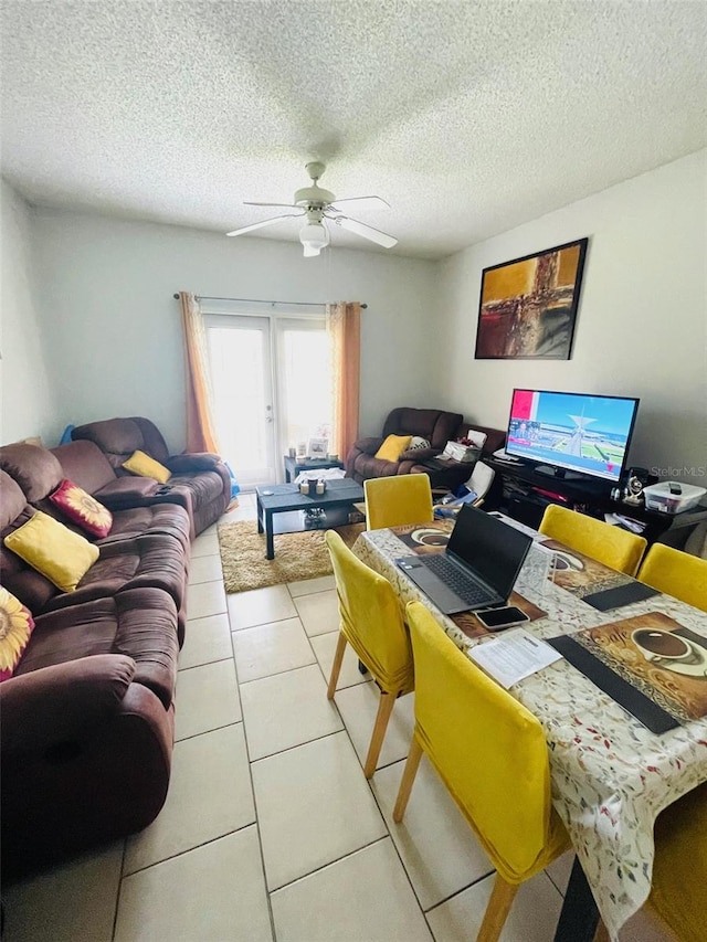 tiled living room with ceiling fan and a textured ceiling