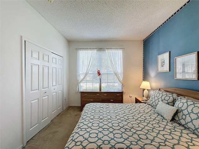 carpeted bedroom with a textured ceiling and a closet