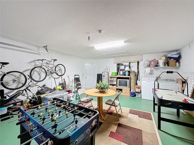 rec room with electric water heater, washer and dryer, and a textured ceiling