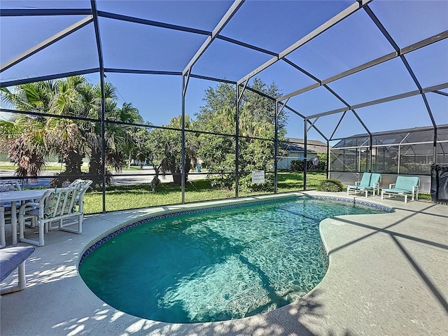 view of pool with glass enclosure and a patio area