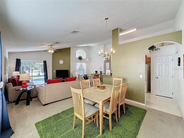 dining room with ceiling fan with notable chandelier, carpet, a textured ceiling, and lofted ceiling