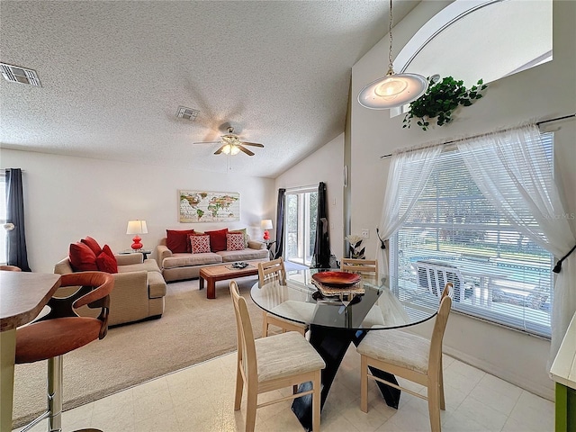 dining area with ceiling fan, vaulted ceiling, and a textured ceiling