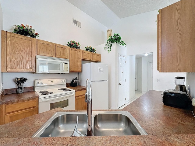 kitchen featuring white appliances, high vaulted ceiling, sink, and a textured ceiling