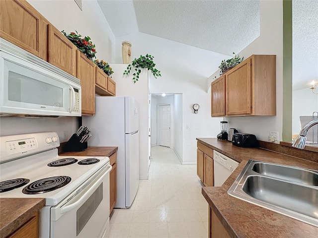 kitchen featuring sink, white appliances, a textured ceiling, and lofted ceiling