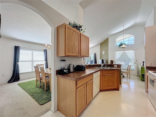 kitchen with white appliances, lofted ceiling, sink, a textured ceiling, and decorative light fixtures