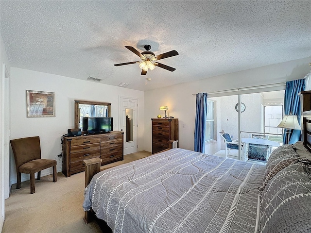 carpeted bedroom featuring ceiling fan and a textured ceiling