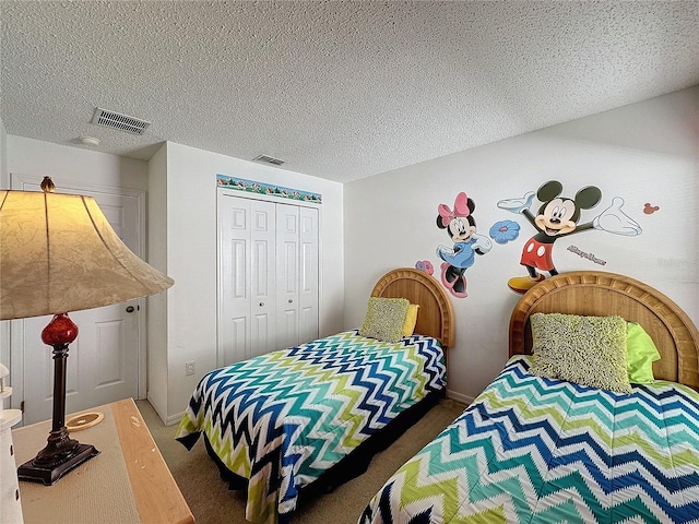 bedroom featuring dark colored carpet, a textured ceiling, and a closet