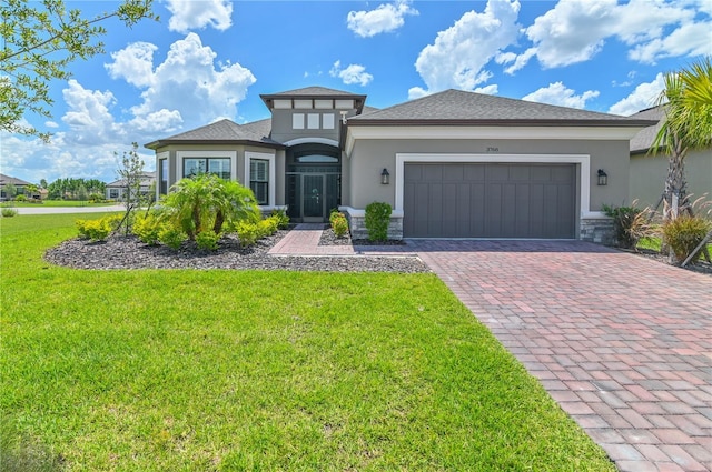 prairie-style home featuring a garage and a front lawn