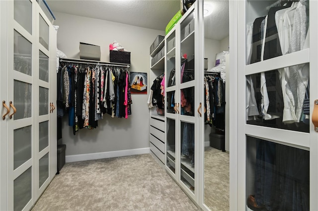 spacious closet featuring light colored carpet