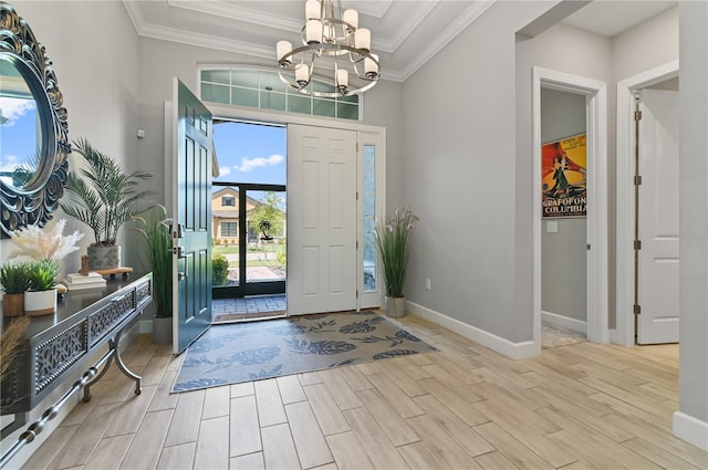 entrance foyer with ornamental molding and a chandelier