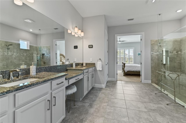 bathroom featuring tile patterned floors, vanity, ceiling fan, and a tile shower