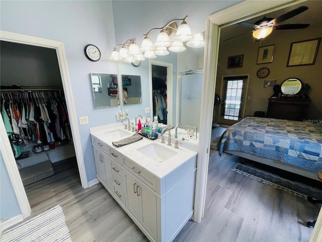 bathroom featuring ceiling fan, hardwood / wood-style floors, vanity, and walk in shower