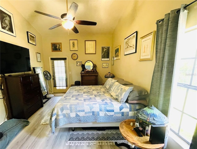 bedroom with ceiling fan, light hardwood / wood-style flooring, and vaulted ceiling