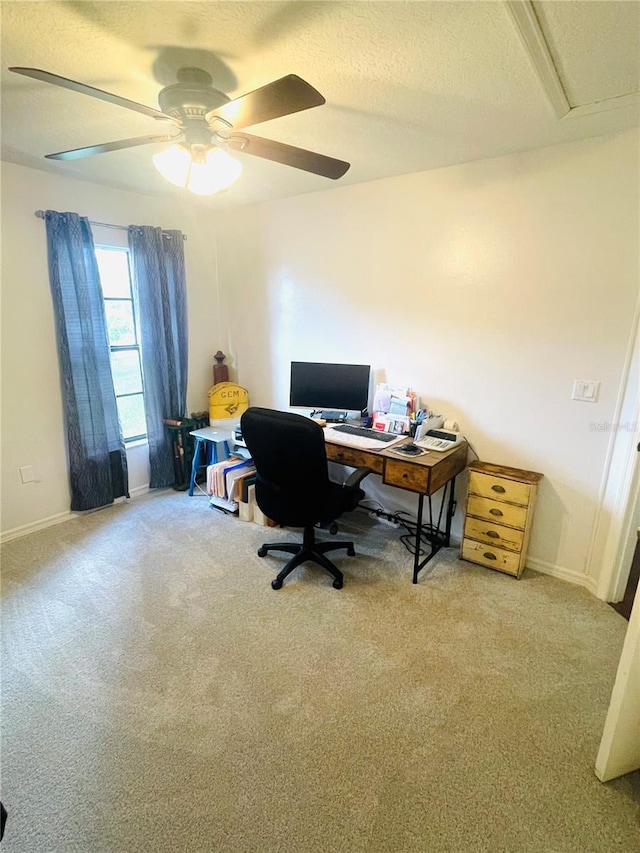 office space featuring ceiling fan, light colored carpet, and a textured ceiling