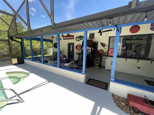 view of patio / terrace with ceiling fan and a lanai