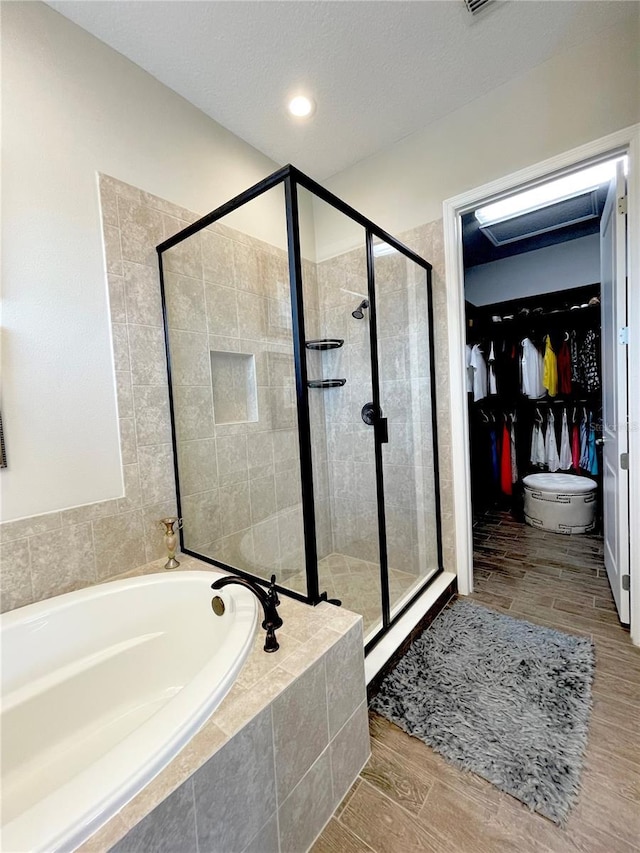 bathroom featuring shower with separate bathtub and a textured ceiling