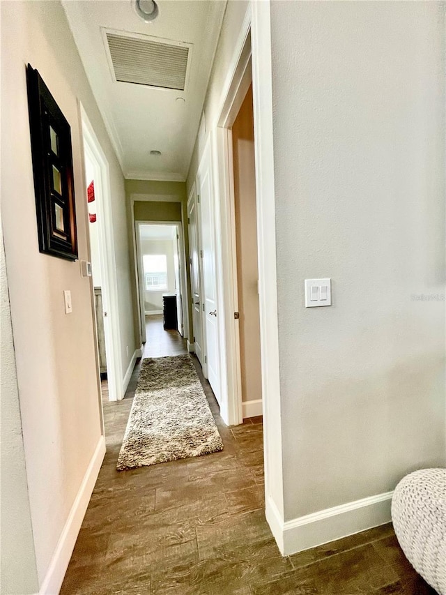 corridor featuring wood-type flooring and crown molding