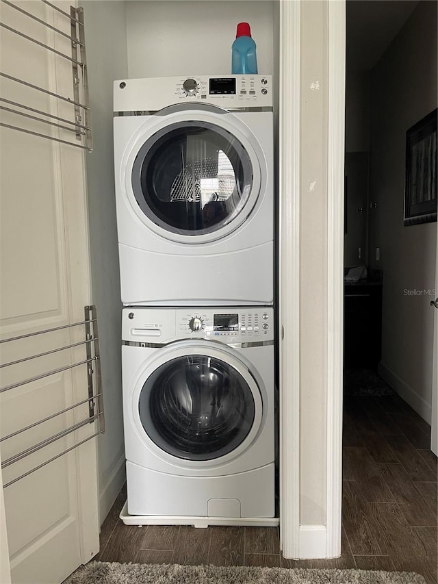 laundry area with stacked washer / dryer and dark hardwood / wood-style floors